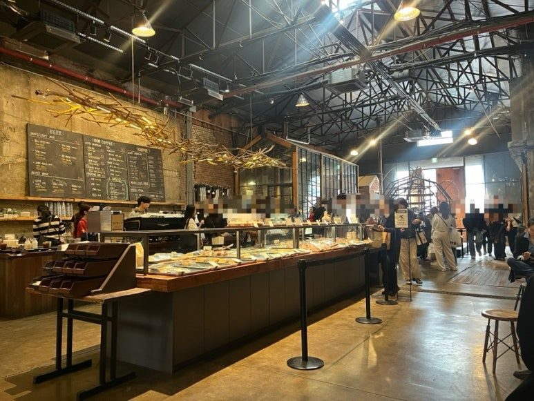 聖水の廃倉庫をリノベした「大林倉庫（대림창고）」カフェ＆ギャラリー内観 高い天井と黒板メニューが並ぶ工業系空間