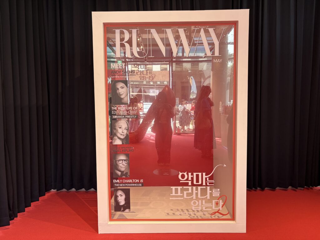 「プラダを着た悪魔2」聖水ポップアップ RANWAYマガジンカバー風セルフフォトゾーン 透明フレームとレッドカーペット背景 SNS映えスポット