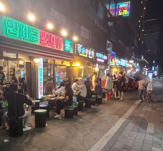 韓国ソウル江南 狎鷗亭洞エリアの夜の飲食店街 ネオンサインと屋外テラス席 韓国ディナー・韓国料理レストランが並ぶ夜景