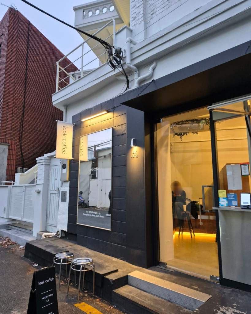 韓国ソウル聖水洞のスペシャルティコーヒー専門店 LOOK COFFEE(룩커피)外観 黒いファサードと暖かい照明の夕暮れの店舗
