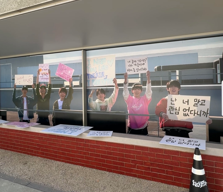 KickFlip(キックフリップ)ポップアップ 4thミニアルバムコンセプトフォト展示空間 メンバーがプラカードを持つ屋外展示パネル