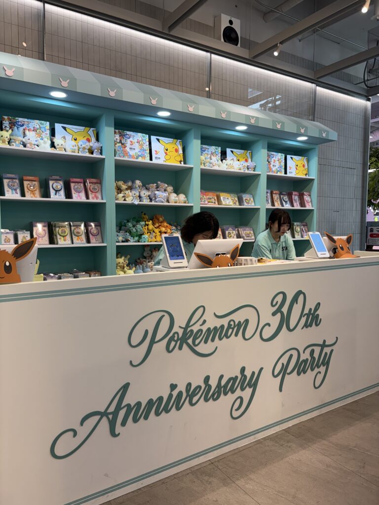 オリーブヤングN聖水「ポケモン30周年アニバーサリーパーティー」コラボレジカウンター ピカチュウグッズが並ぶターコイズ棚
