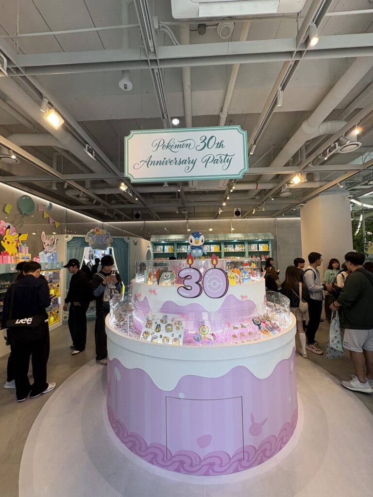 オリーブヤング聖水ポケモン30周年コラボ 店内中央のバースデーケーキ型ディスプレイとポッチャマオブジェ 限定グッズ販売コーナー