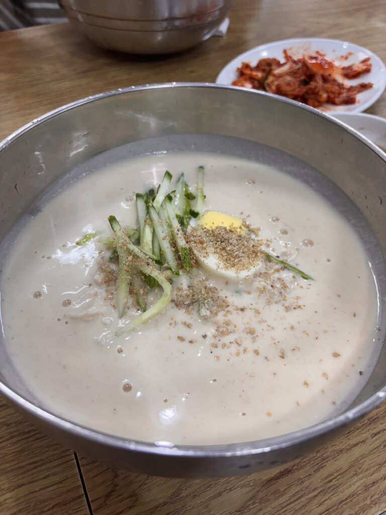 韓国の夏グルメ・コングクス(콩국수)-きゅうりとゆで卵をのせた冷たい豆乳麺とキムチの小皿